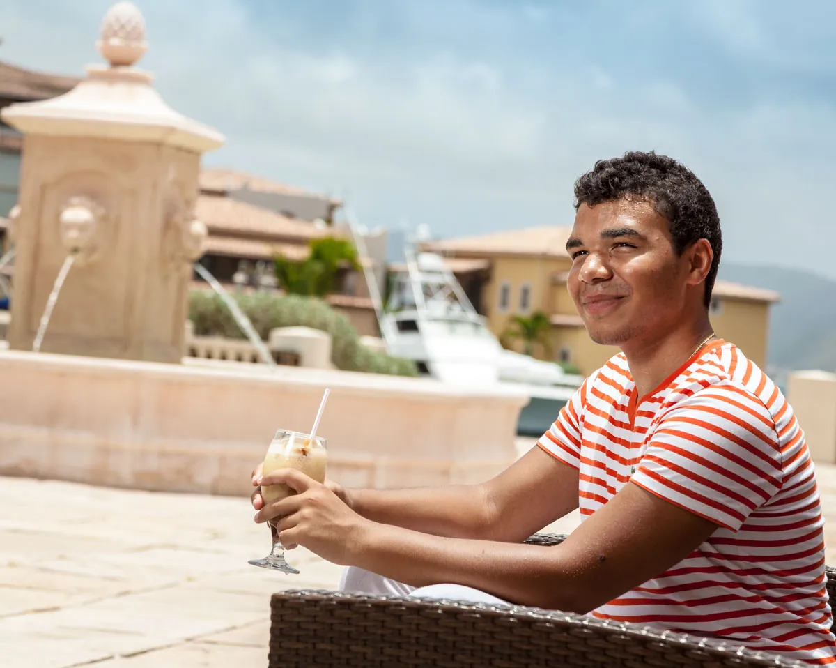 Guest sipping a fresh blended cocktail by the plaza fountain