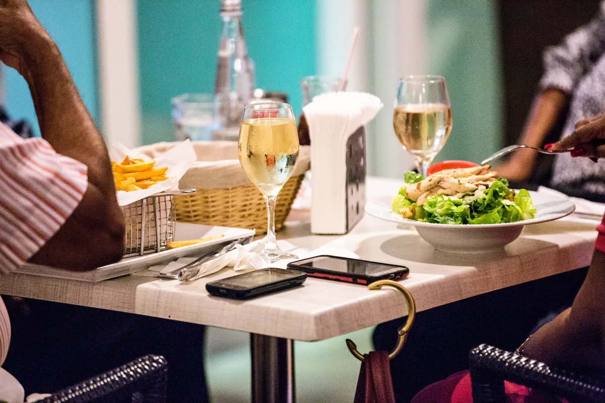 Elegant lunch table with white wine, salad and crispy fries