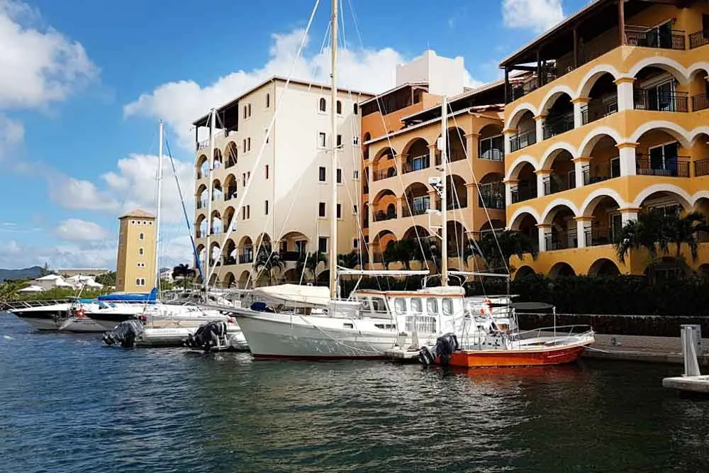 Boats moored along the Porto Cupecoy quays under a blue sky